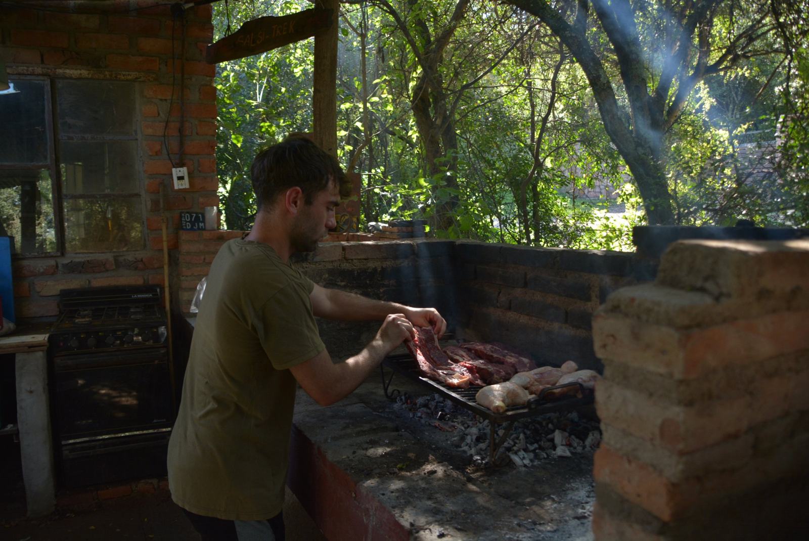 Host preparing an Argentine asado on the grill