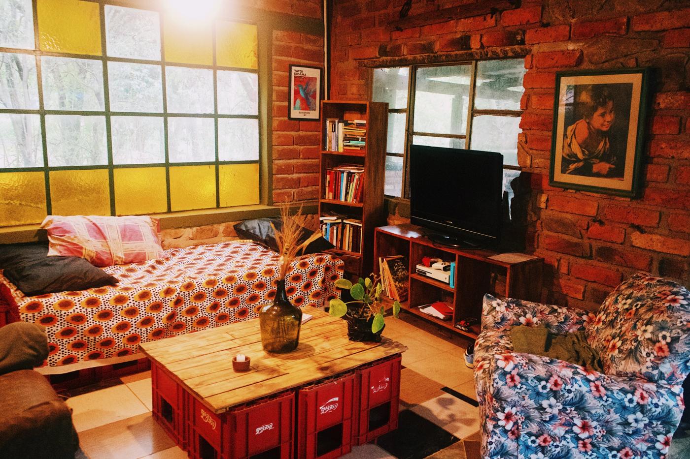 Hostel living room with brick walls and colorful cushions